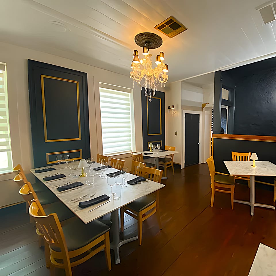 Elegant dining room at The Barton House of Salado, featuring a long table set with wine glasses.